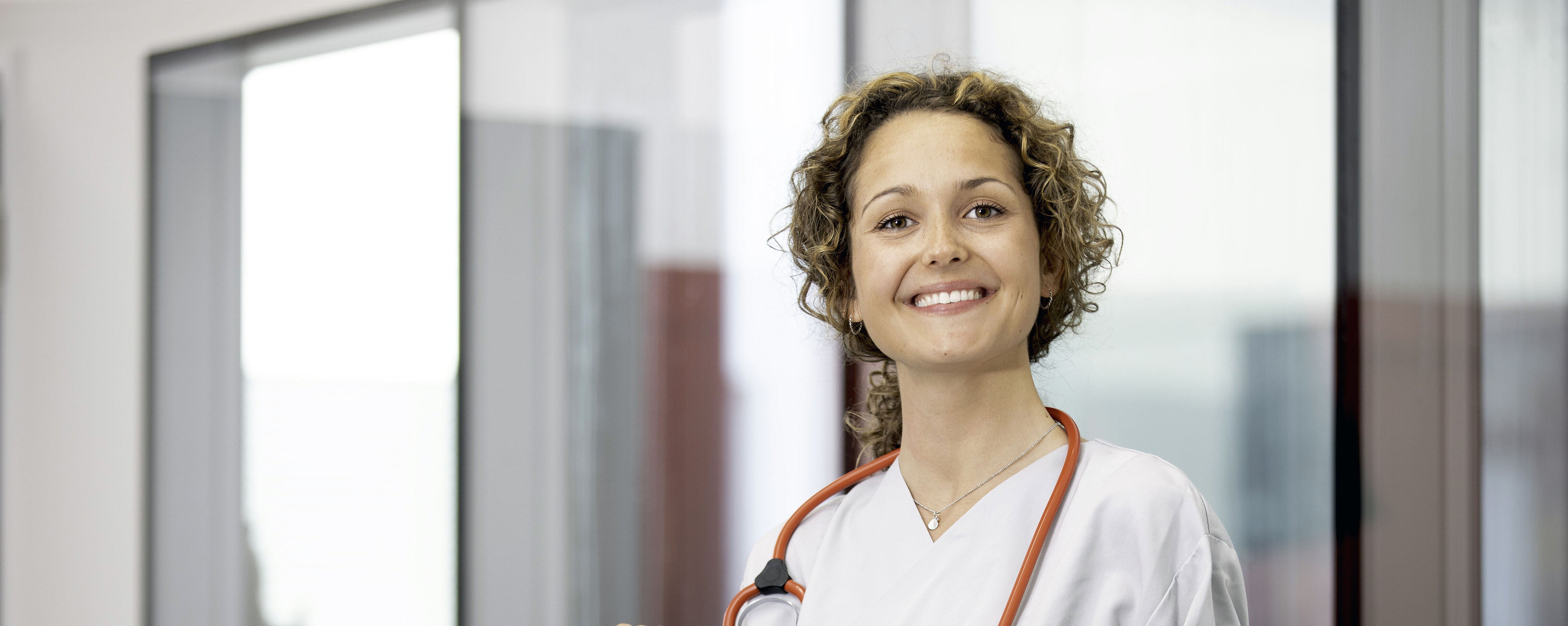 lächelnde Krankenschwester mit Stethoskop um den Hals