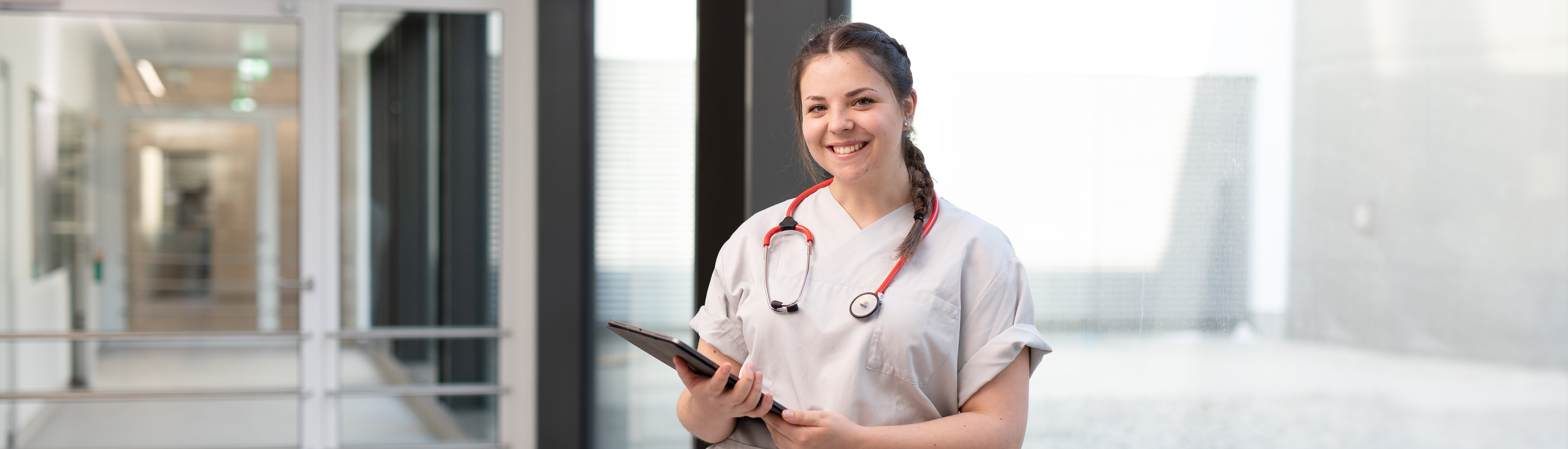 lächelnde Krankenschwester steht auf dem Gang