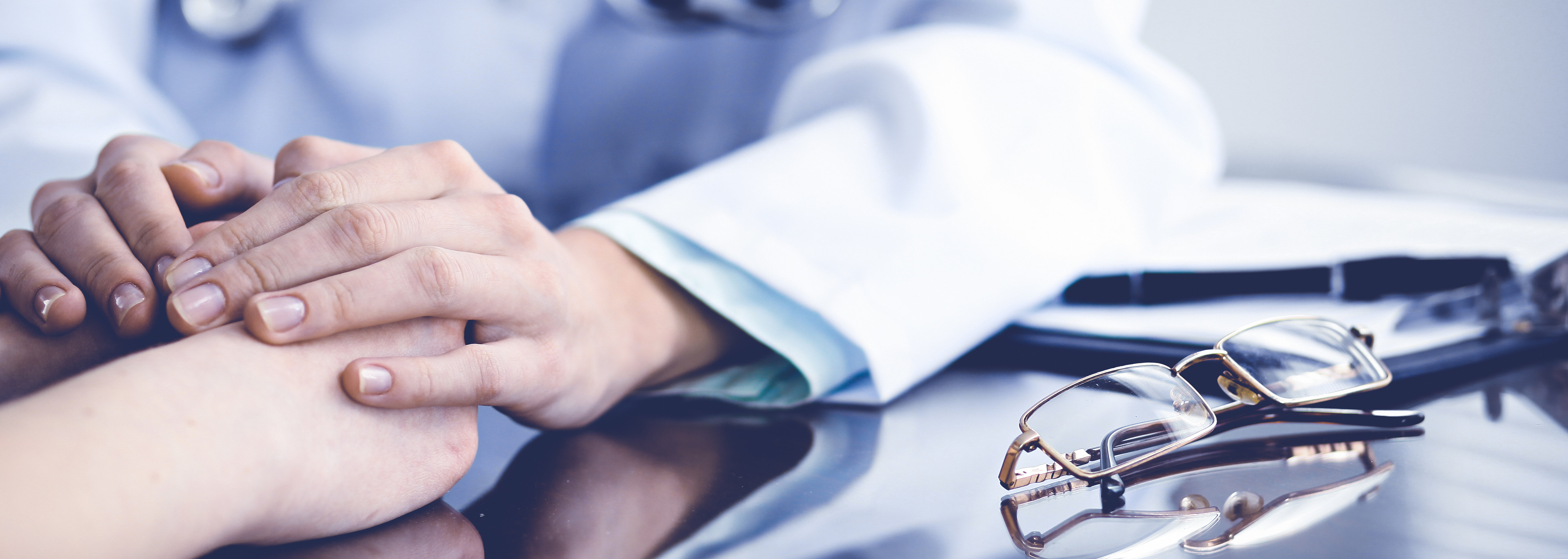 Arzt hält mit seinen Händen zwei andere Hände