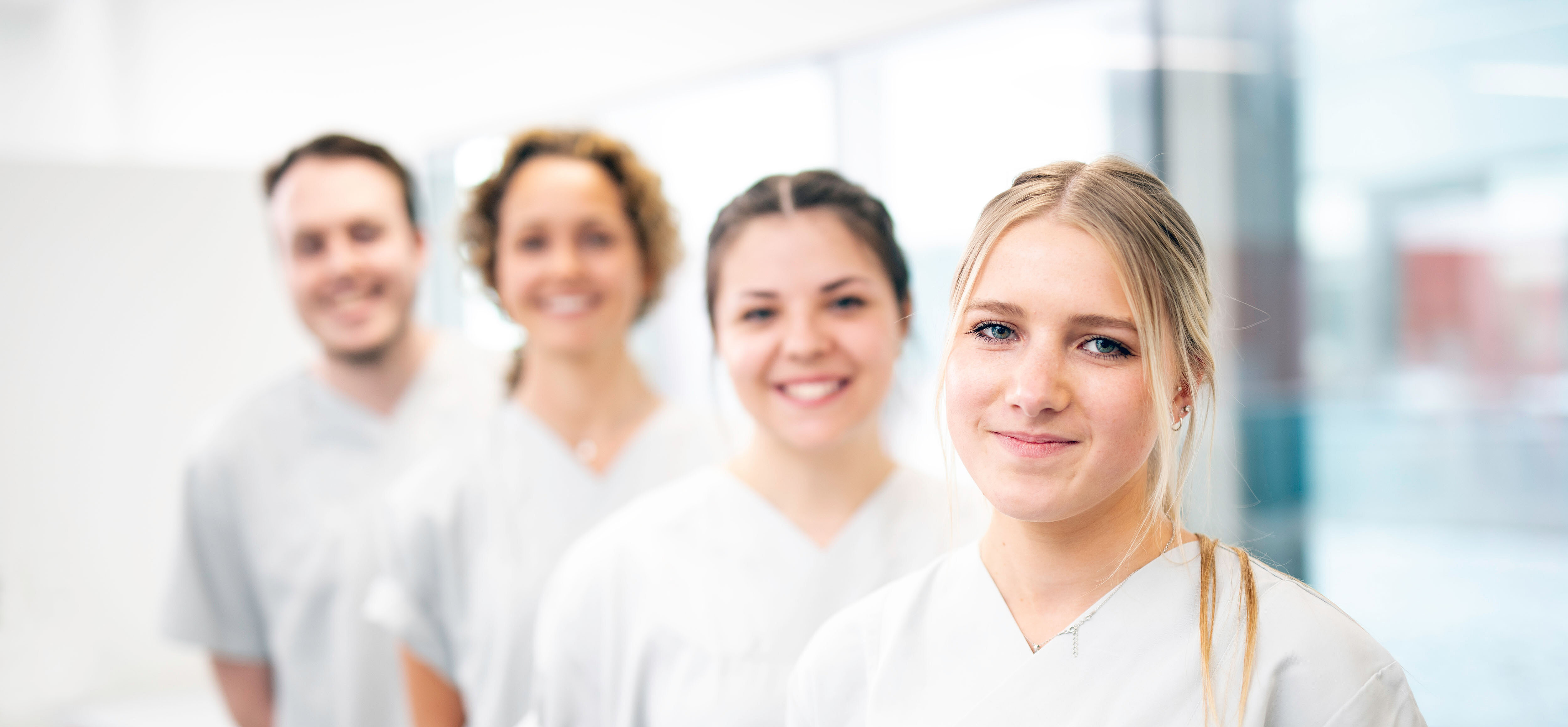 vier Pfelgekräfte in weißen Kasak stehen leicht versetzt hintereinander