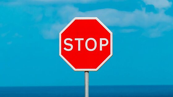 ein Stop-Schild- im Hintergrund blauer Himmel mit Wolken