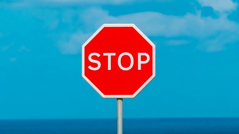 ein Stop-Schild- im Hintergrund blauer Himmel mit Wolken