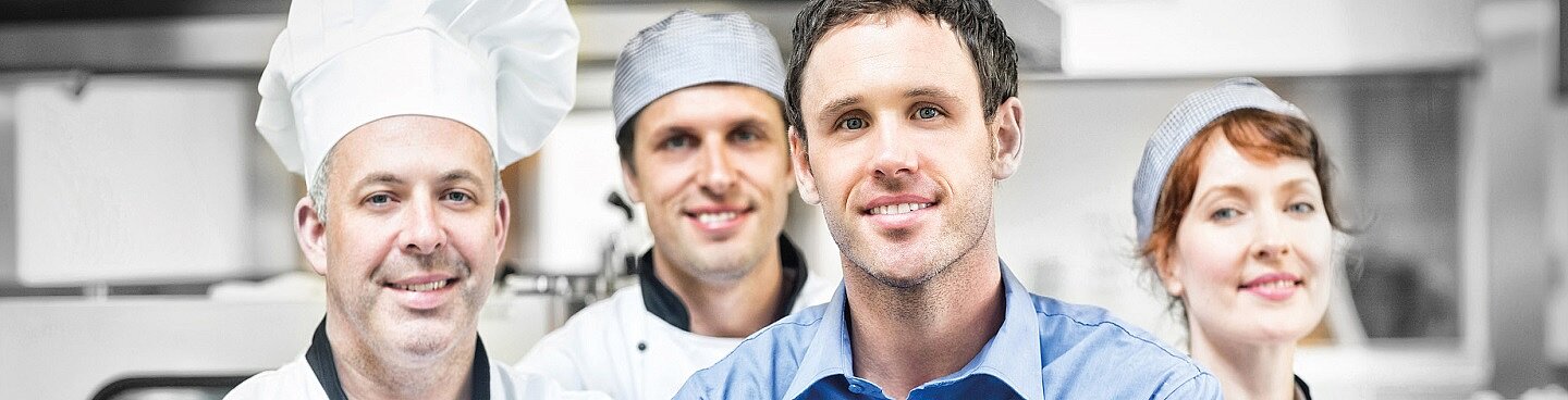 vier Personen mit Arbeitskleidung