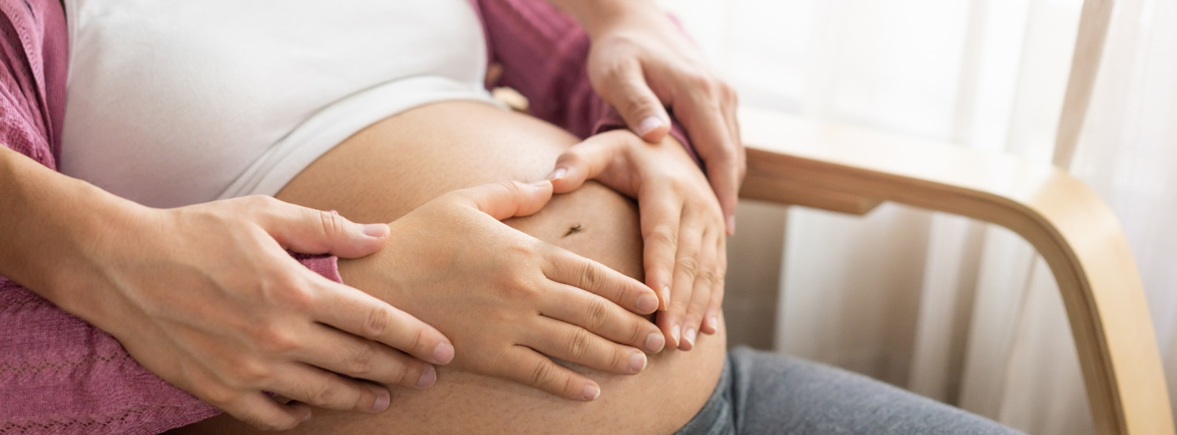 Schwangere streichelt den nackten Schwangerschaftsbauch