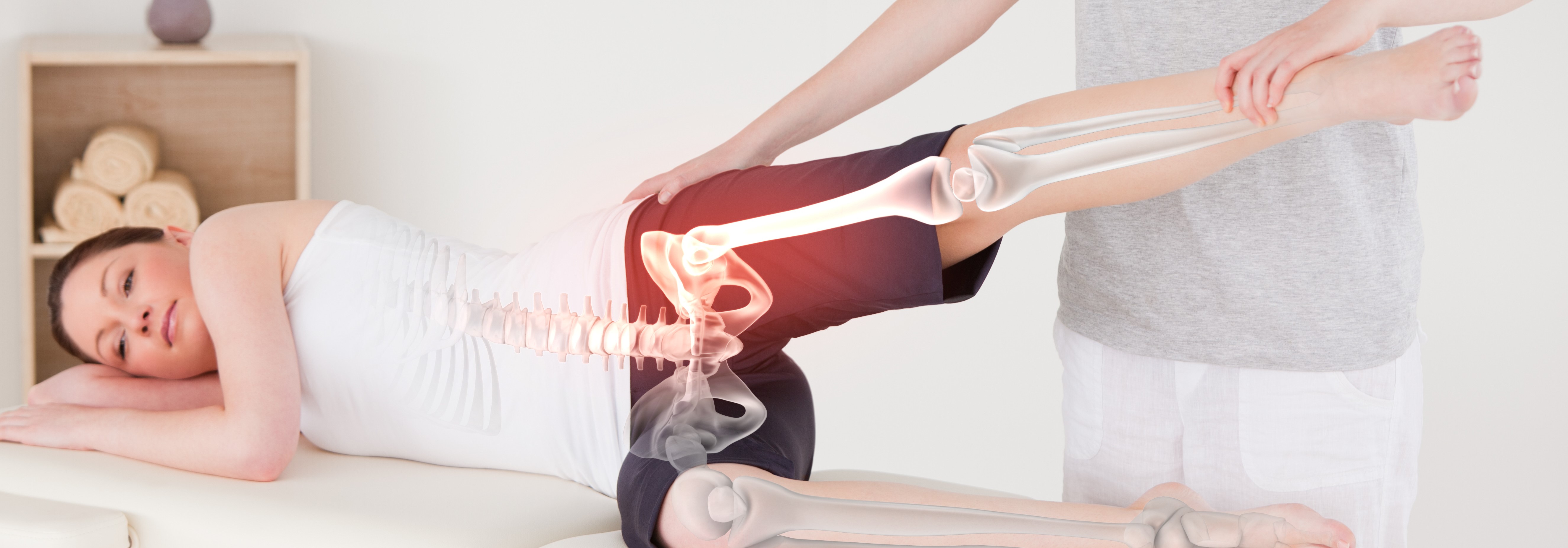 Patient liegt seitlich auf der Behandlungsliege. Therapeut bewegt die rechte Hüfte