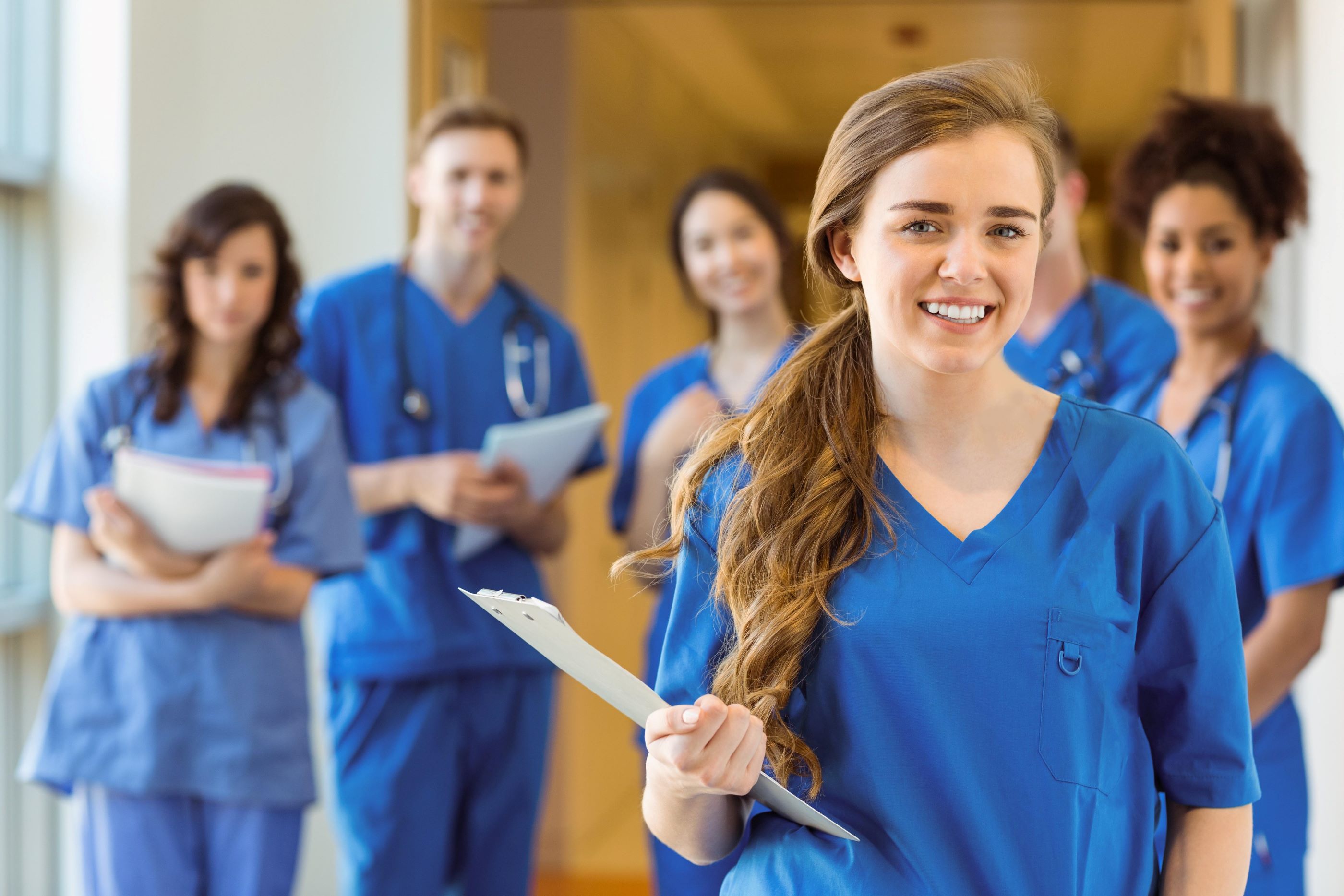 5 Pflegekräfte in blauer Dienstkleidung